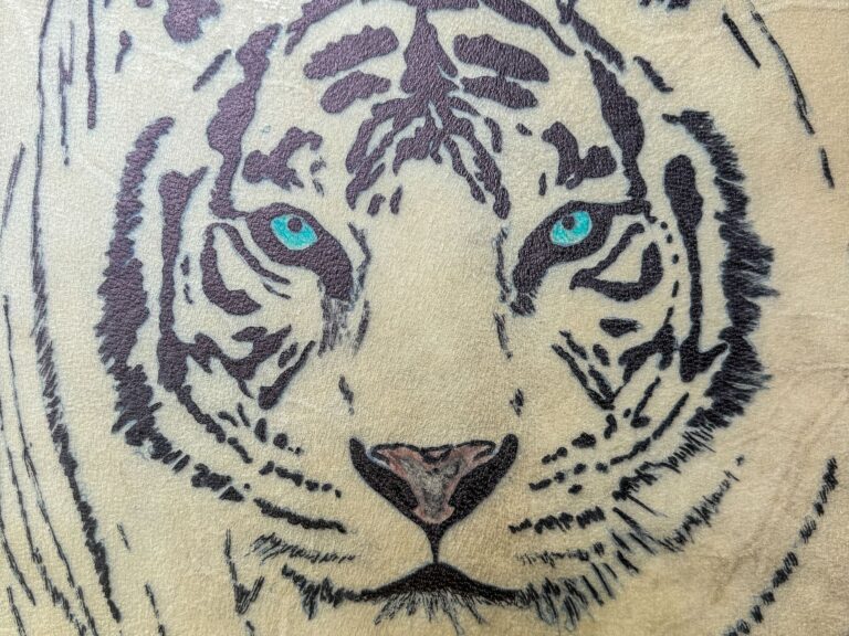 Hình xăm đầu hổ với mắt xanh nổi bật.