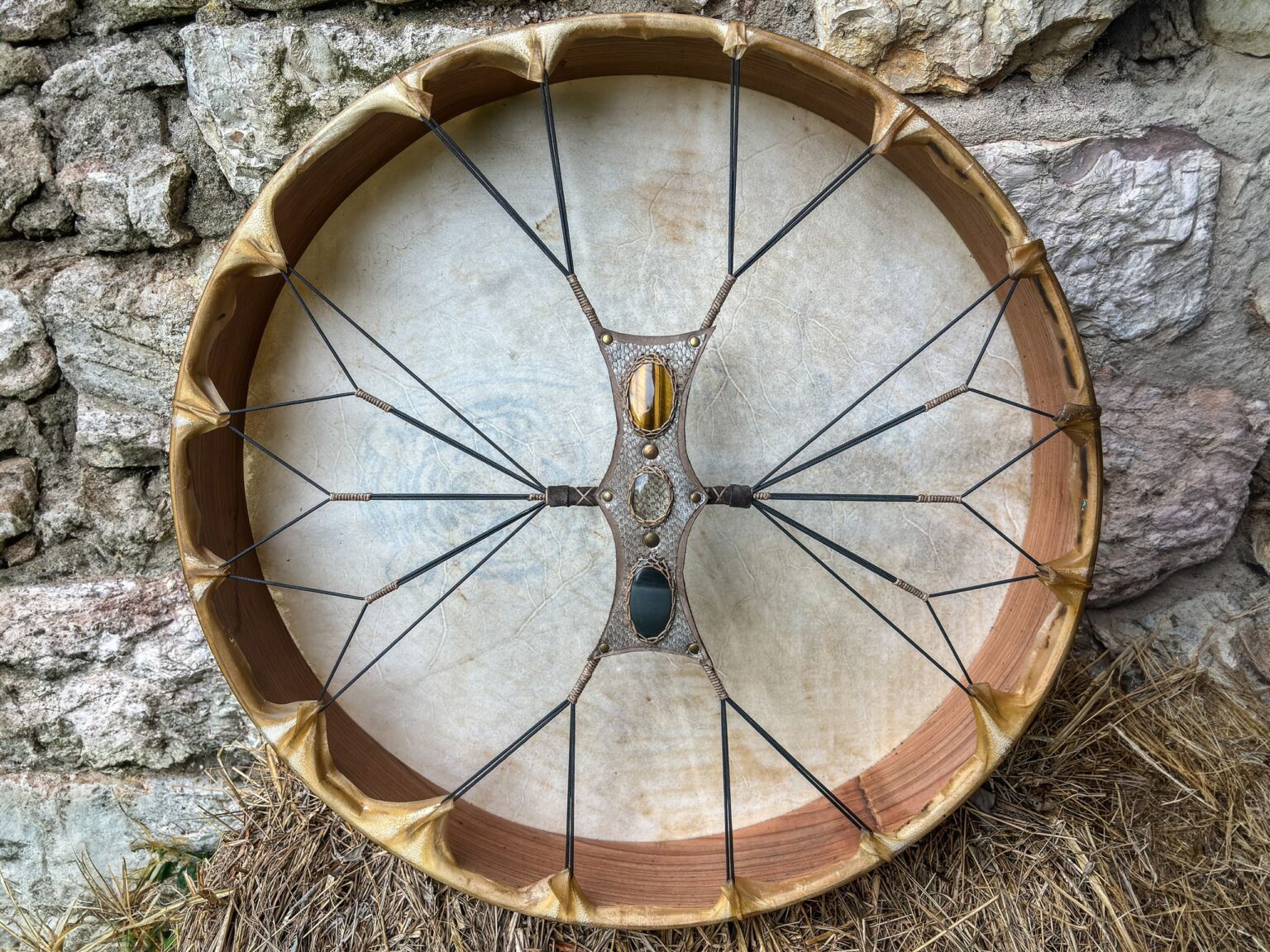 Trống da hình tròn trước bức tường đá.