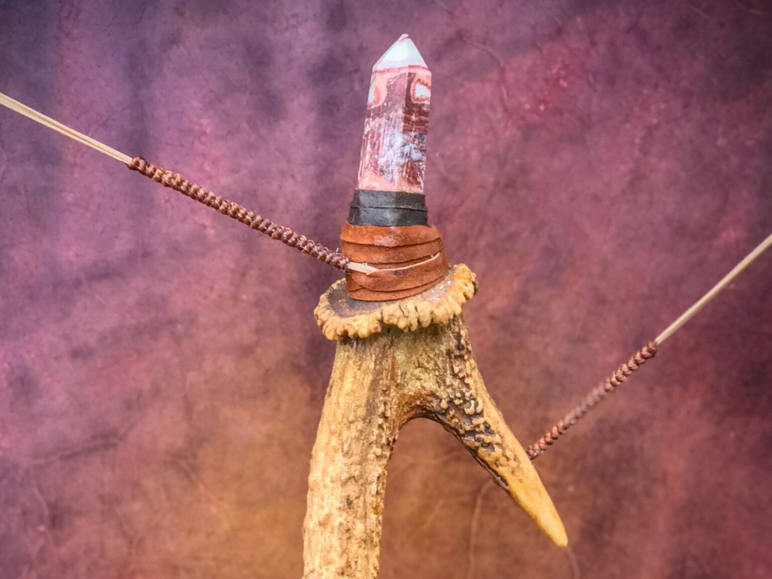 Đầu mũi tên đá trên nền tím nghệ thuật.