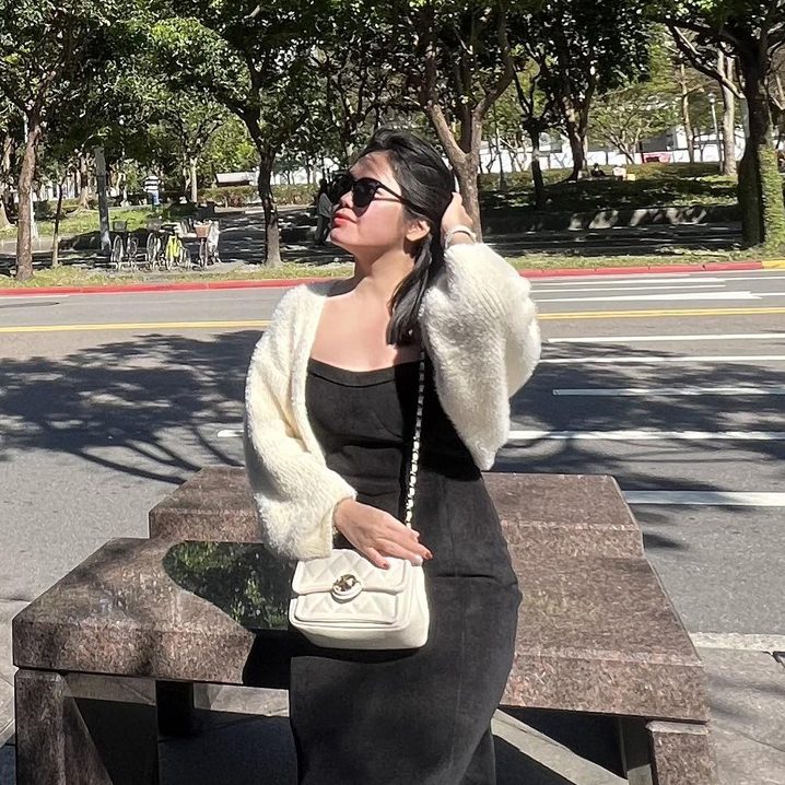 Người phụ nữ đứng ngoài trời, mặc váy đen