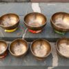 Bát hát Tây Tạng đặt trên đá xám. Bộ 7 Chuông Full Moon Hệ Vedic 17-28cm – By Santa Ratna Shakya