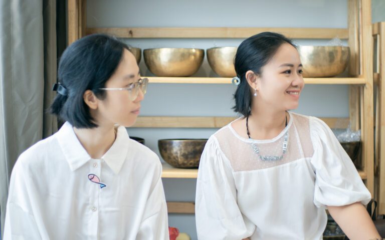 Khóa Học Gieo Duyên Cùng Chuông Xoay Himalaya 17-18/08/2024 24 Hai phụ nữ trẻ trò chuyện trong nhà bếp