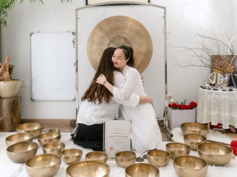 Người phụ nữ ôm nhau gần chuông đồng lớn