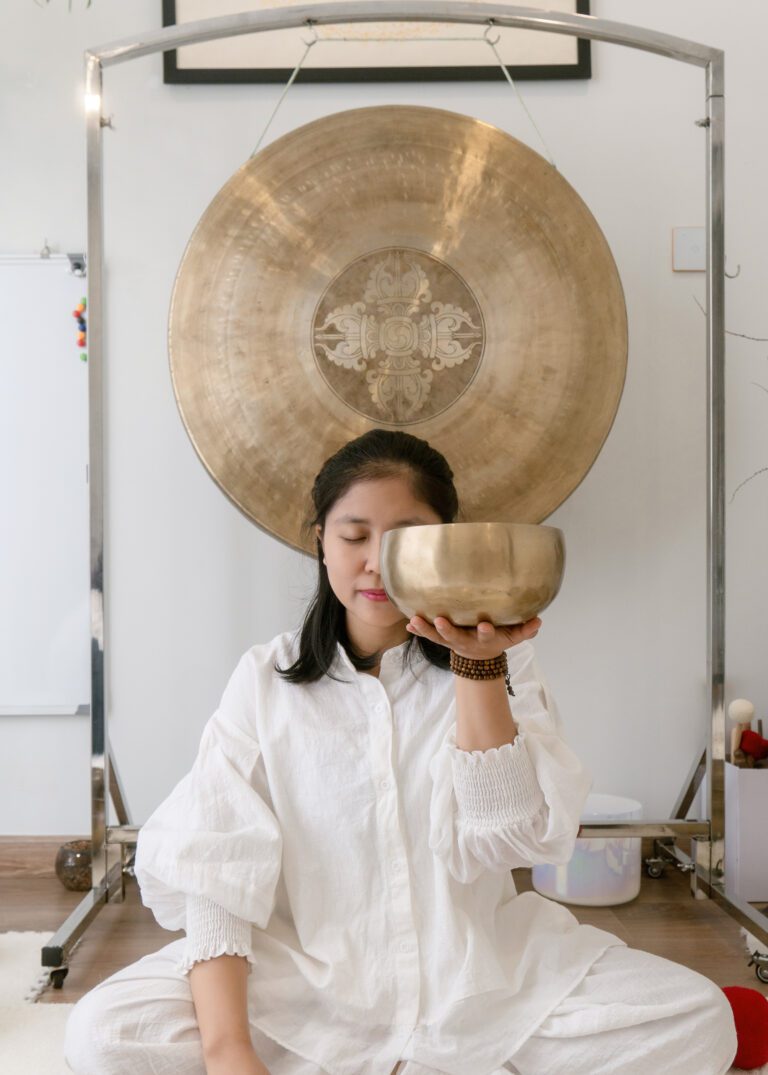 Người phụ nữ ngồi thiền với bát đồng lớn.