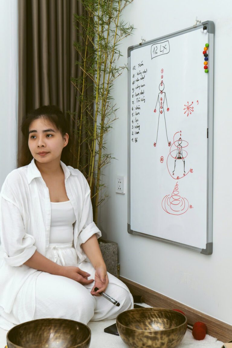 Bên Trong 1 Lớp Học Chuông Tại Madahuma Healing 24 Người phụ nữ bên bảng vẽ sơ đồ cơ thể.
