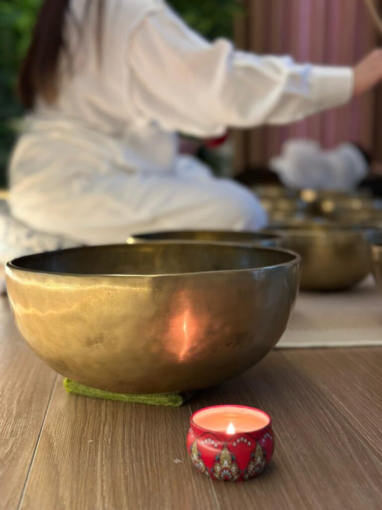 Chuông đồng và nến đỏ trên sàn gỗ