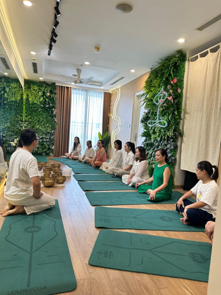 Lớp học yoga trong phòng với nhiều học viên.