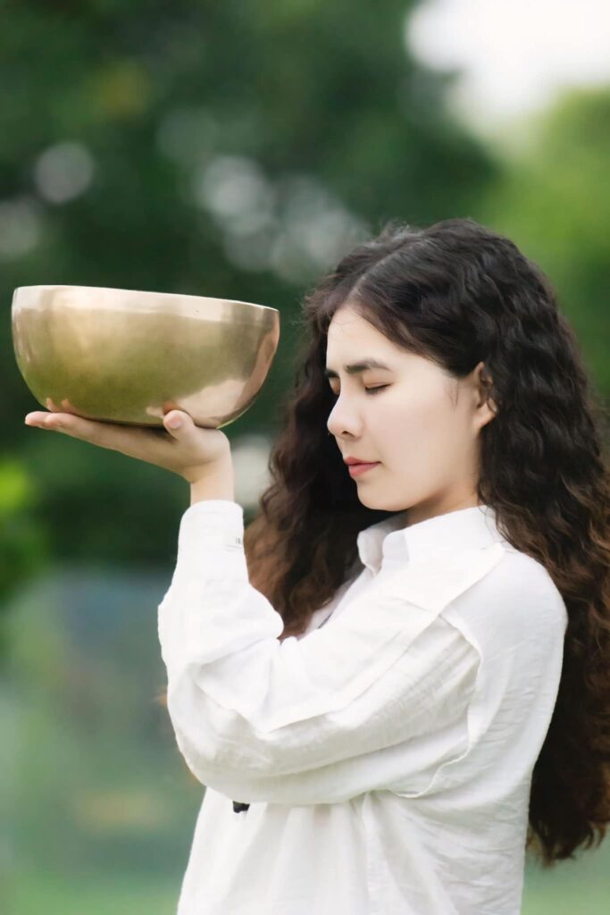Người phụ nữ cầm bát thiêng, nhắm mắt lại.