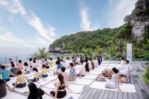 Buổi yoga ngoài trời tại bãi biển xanh.