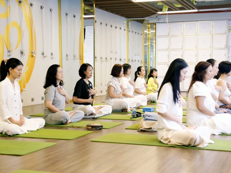 Nhóm phụ nữ thực hành thiền yoga trong phòng.