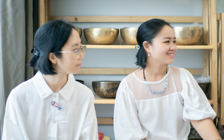Hai phụ nữ trẻ trò chuyện trong nhà bếp