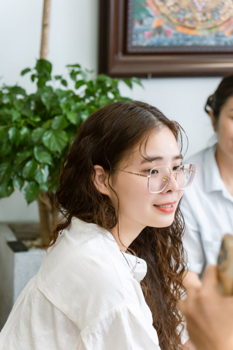 Người phụ nữ trẻ đeo kính và mỉm cười