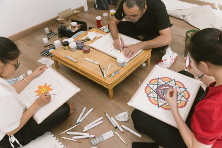 Người vẽ tranh mandala trên sàn gỗ