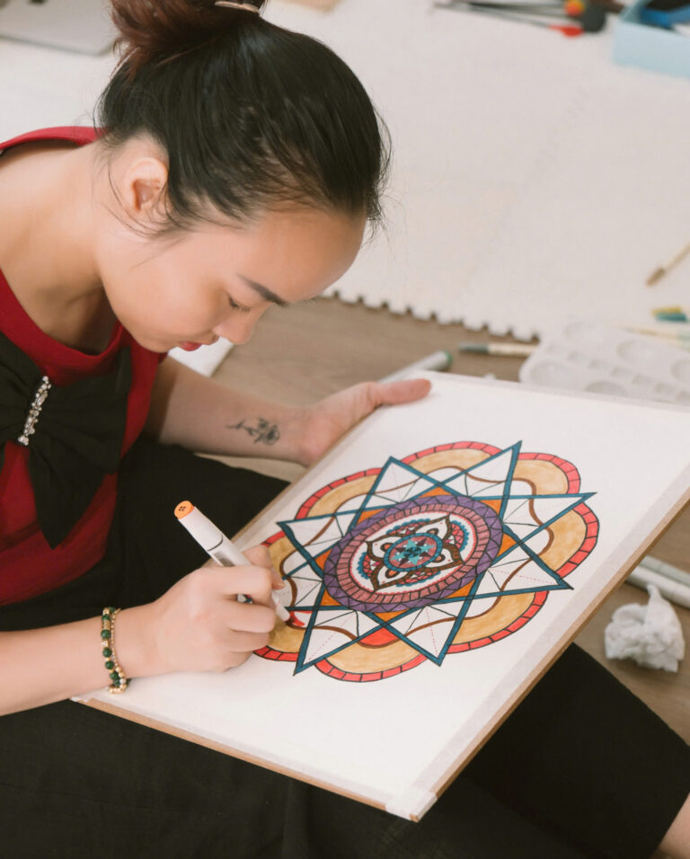 Người phụ nữ vẽ tranh mandala trên giấy
